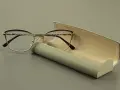 Eleganckie okulary z fioletowymi oprawkami i szkłami sferycznymi, obok futerału.