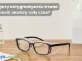 Okulary ochronne na drewnianym blacie, obok płynu do dezynfekcji i maseczki. Czy przy astygmatyzmie trzeba nosić okulary cały czas?