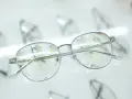 Okulary do bliży i dali z oznaczeniami L i R. Soczewki mają zaznaczone obszary widzenia, ułatwiające dobór korekcji.