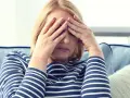 Kobieta z ucisk w głowie i zaburzenia widzenia, trzymająca się za czoło.