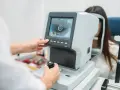 Badanie dna oka w ciąży. Lekarz wykonuje badanie wzroku pacjentce przy użyciu nowoczesnego sprzętu.