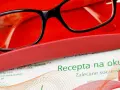 Okulary w etui na tle recepty. Ważność recepty na okulary jest kluczowa dla zakupu odpowiednich soczewek.