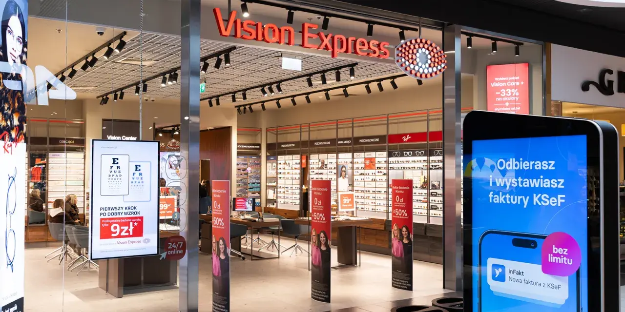 Witryna sklepu Vision Express z ekspozycją okularów i ekranem informacyjnym.