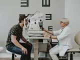 Okulista bada wzrok pacjenta za pomocą specjalistycznego urządzenia.