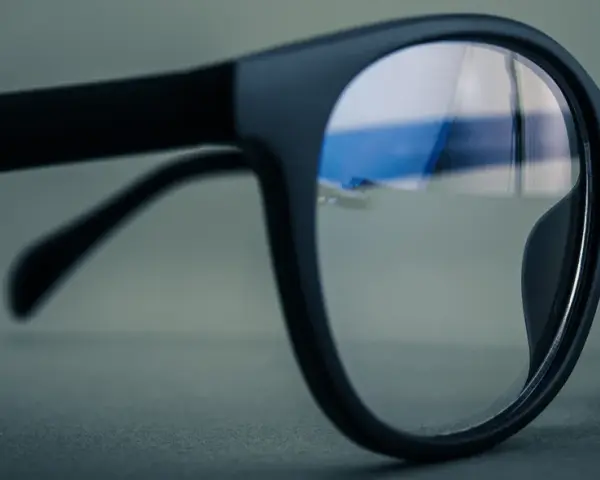Czarne okulary z soczewkami z powłoką antyrefleksyjną. W odbiciu widać niebieskie światło, sugerujące antyrefleks zielony czy niebieski.