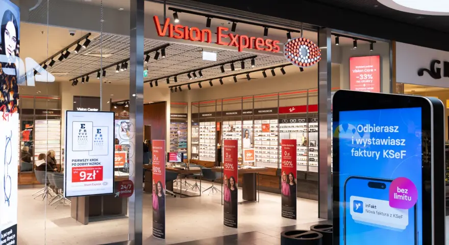 Witryna sklepu Vision Express z ekspozycją okularów i ekranem informacyjnym.