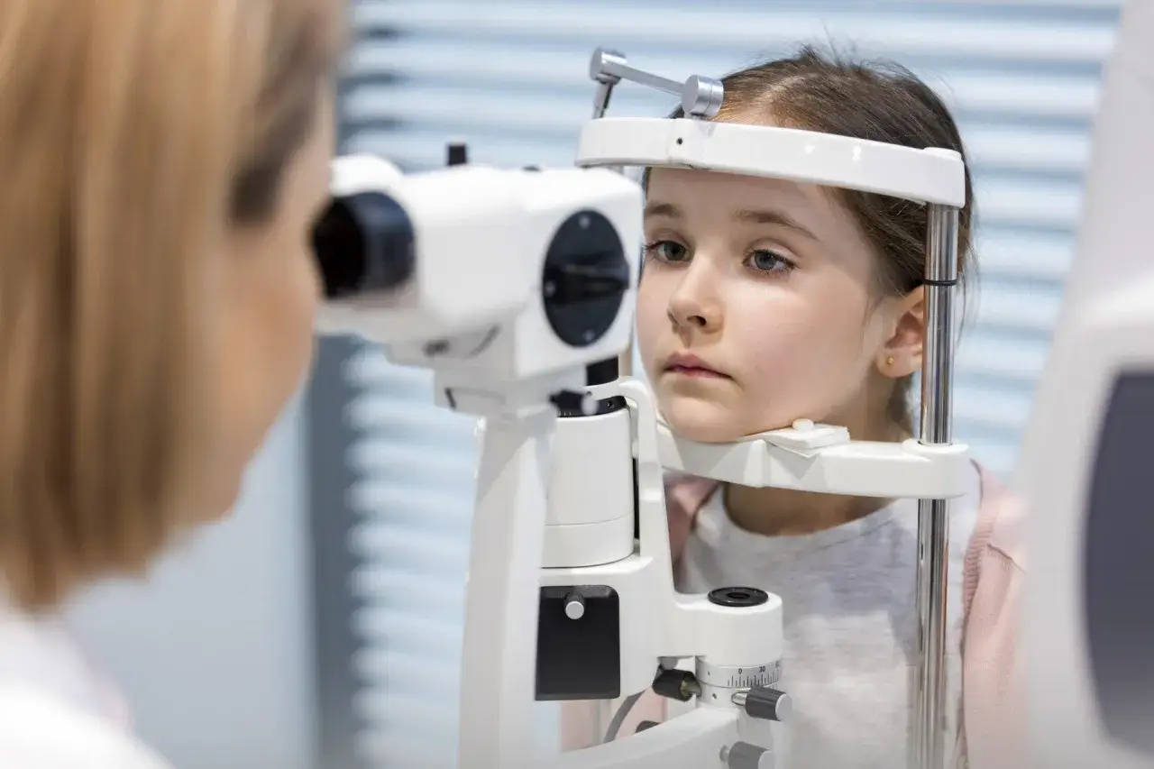 Dziewczynka podczas badania okulistycznego, które może pomóc w diagnozie wrodzonej ślepoty Lebera.